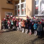 Przedszkolaki i nauczyciele śpiewają hymn narodowy